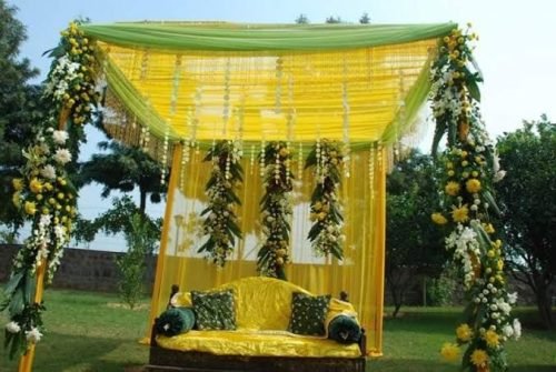 Haldi Stage Decoration With Marigold Flowers And Cushions – Phule Weddings
