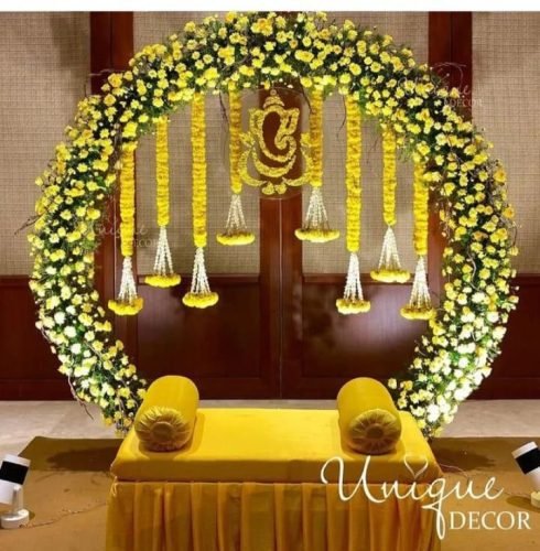 Mehndi Celebration Stage With Marigold Strings And Traditional Backdrop | Phule Weddings